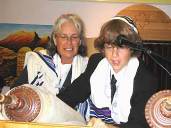 Julian reads his Torah portion as Rabbi Shillor looks on.